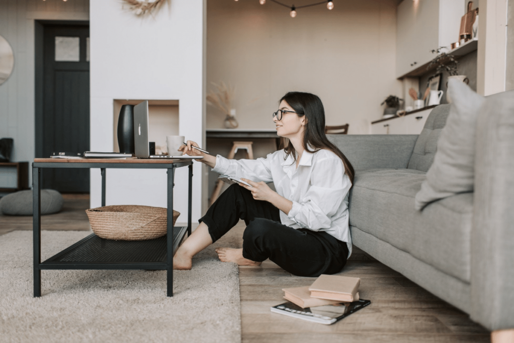 female sitting on floor in living room working on blog to make money 