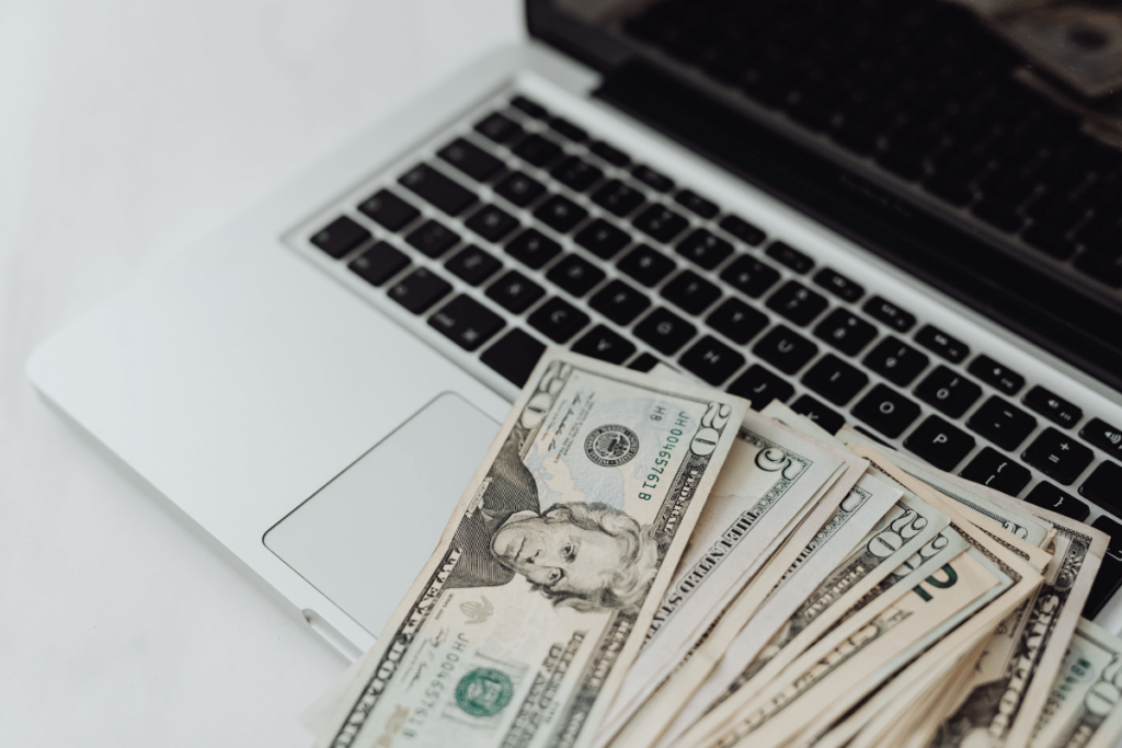 laptop with money on top of it. Making money from blogging 