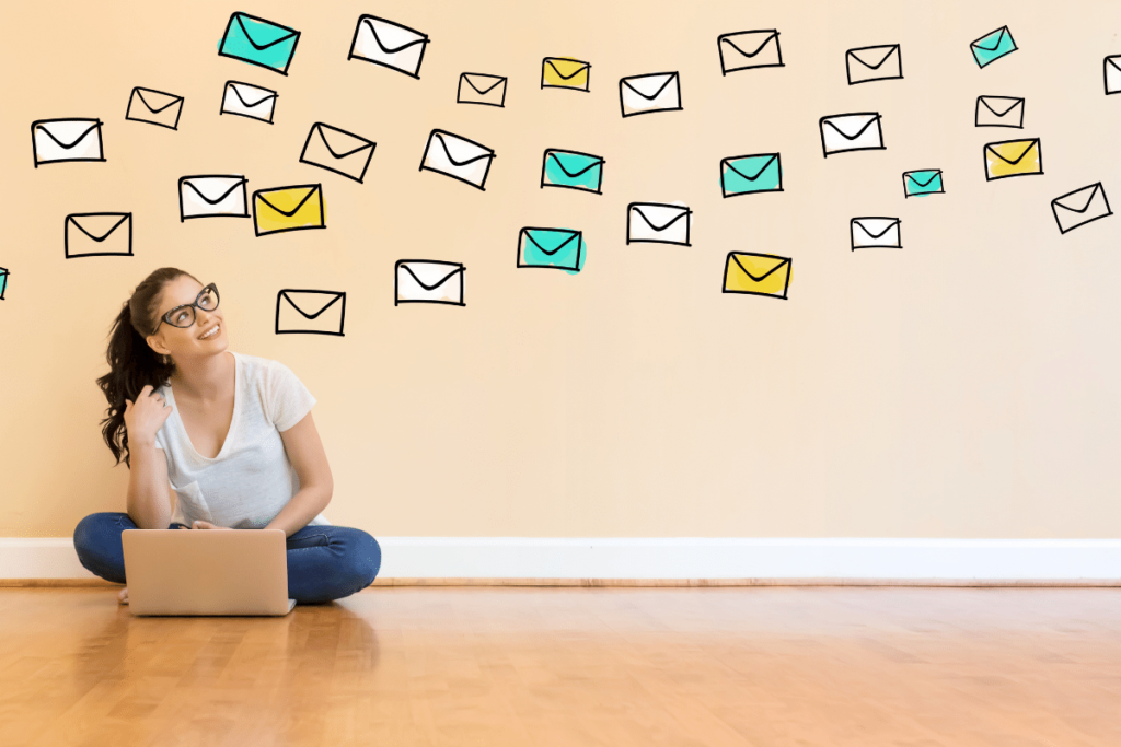 lady sitting on ground with computer with email icons all around her
