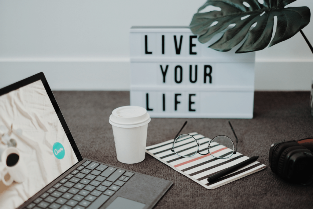 laptop with a sign that says live your life- why is blogging important for home businesses